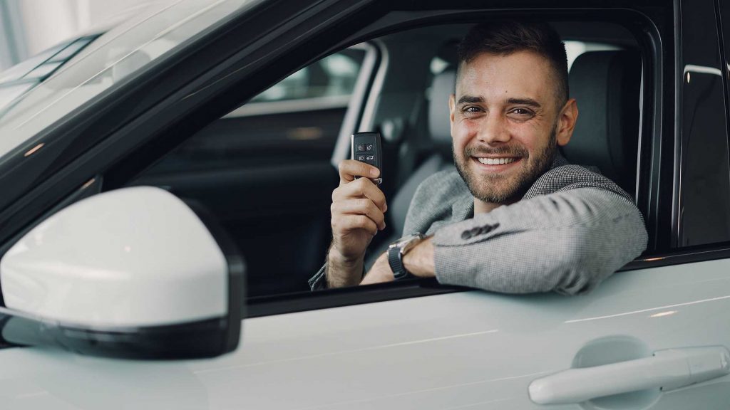 guy showing car keys in a car